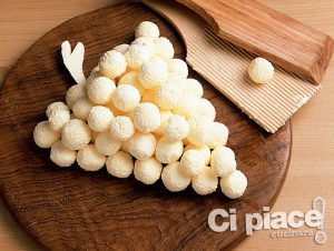 Butter balls on wooden board in shape of bunch of grapes
