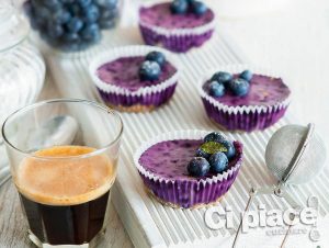 Mini blueberry cheesecakes on a white chopping board